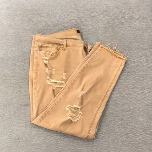 Distressed mustard jeans with fringe.